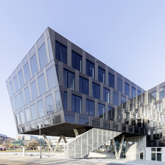 Glänzender Funke-Neubau: Die auf V-förmigen Betonstützen ruhenden Stockwerke besitzen eine dunkle Fassade aus grau durchgefärbtes Floatglas, was der Gebäudehülle einen intensiven Glanz verleit.