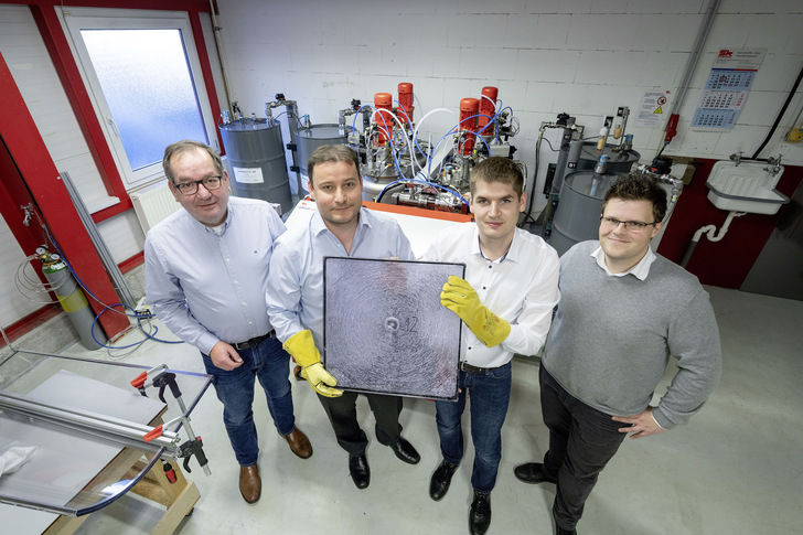 Nach einem Beschusstest präsentieren (v. l.) Firmeninhaber Eberhard Scheidel, Dr. Christian Scherer (H.B. Fuller | Kömmerling), Sohn Moritz Scheidel und Benjamin Gantner (H.B. Fuller | Kömmerling) eines der neuen Verbundelemente. 