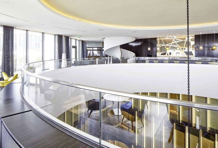 Durch das gleichmäßig gerundete, horizontale Glasgeländer der MetallArt Treppen GmbH kann man in der Fontenay Bar einen Blick in das 27 m hohe Atrium des Hamburger Hotels werfen.