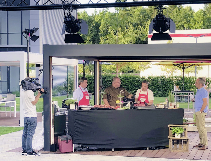 Auf die Technik kommt es an: BBQ-Experte Martin Rubner zeigt Alexander Grundhoff (links) und Stephan Kliegl (rechts), worauf bei der Zubereitung von Grillfleisch zu achten ist.