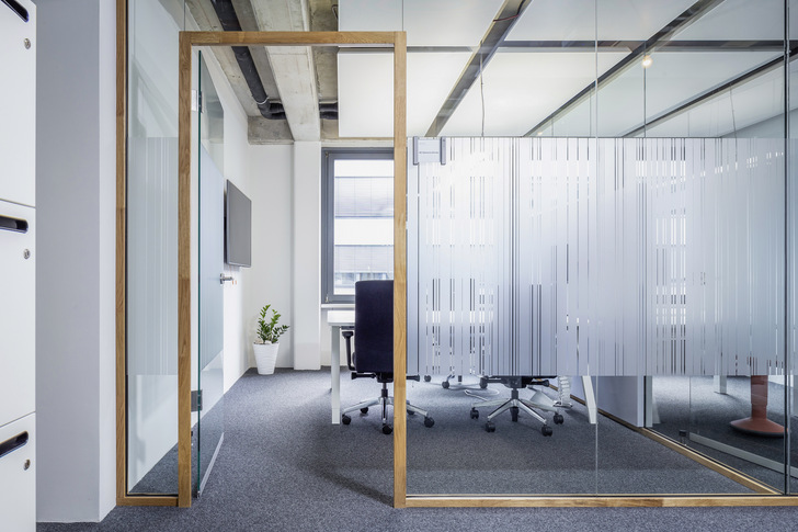 Das klare Design des Trennwandsystems von Lindner vereint die Vorteile einer Ganzglaswand mit einem Holzprofil, das einfach an Decke und Boden angeschlossen werden kann. 