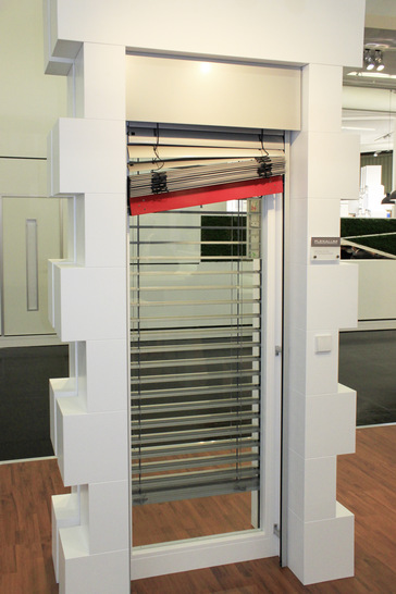 Das Fluchtraffsystem für den zweiten Rettungsweg verfügt über eine spezielle Unterschienenkonstruktion, die es ermöglicht, den Behang bei Bedarf manuell hochzuschieben und dank spezieller Exzenterbolzen in jeder gewünschten Position zu fixieren.