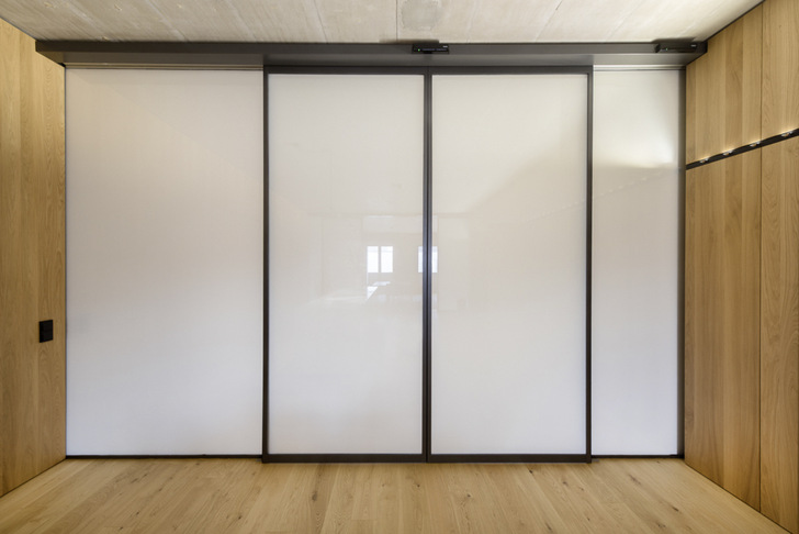 Integrierte Ganzglassysteme von Geze lassen sich per Knopfdruck  zum sichtgeschützten Raum verwandeln. Der Einsatz schaltbare Gläser macht dies möglich.