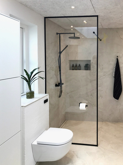 Hier eine gläserne Duschtrennwand von DSG Industri A/S. Hierfür und fü﻿r Dusch­türen ­werden spezielle ­Gläser mit und ohne wasser­abweisende Nano-­Beschichtung angeboten