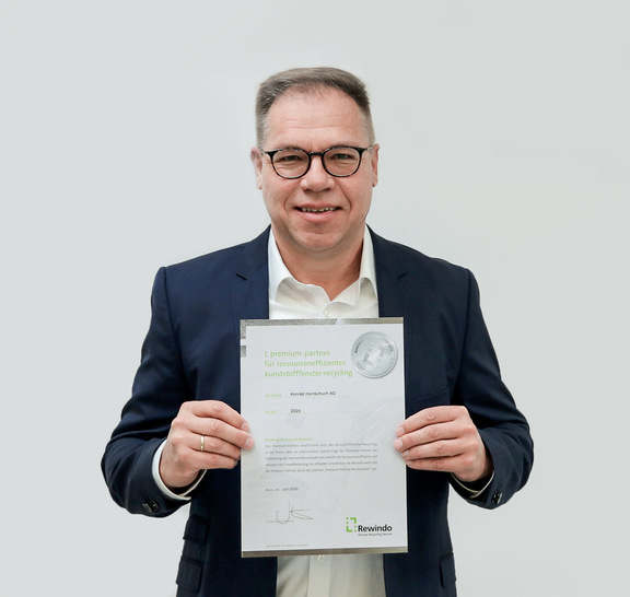 Rainer Irouschek, Leiter des Exteriorbereichs für Oberflächenmaterialien bei Continental, mit der Urkunde über die Premium-Partnerschaft.