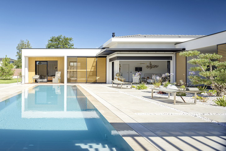 Loggia-Schiebeläden und Fixscreen-Textilsonnenschutz bieten Sicht- und Sonnenschutz. Das Carmague-Lamellendach fügt sich perfekt als Ruheraum ﻿vor dem Pool ein.