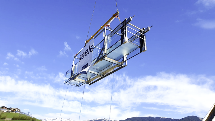 Schwebend: Der Glassteg wurde mithilfe ­eines 45 Meter langen Auslegers über das Bründls Sports-Gebäude zur Einbaustelle im vierten 
Ober­geschoss gehoben.