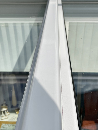 01: Von außen durch die Scheiben fotografiert wird deutlich, dass die Scheiben die innere weiße Wand in unterschiedlichen Farben zeigen.