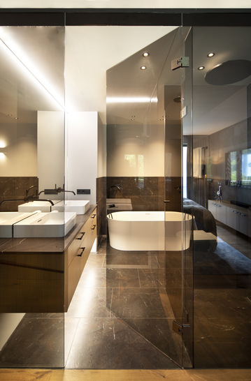 Nach der Sanierung bilden  Türen aus grauem Parsol Glas eine klare Abtrennung zwischen den Bädern und Schlafzimmern.