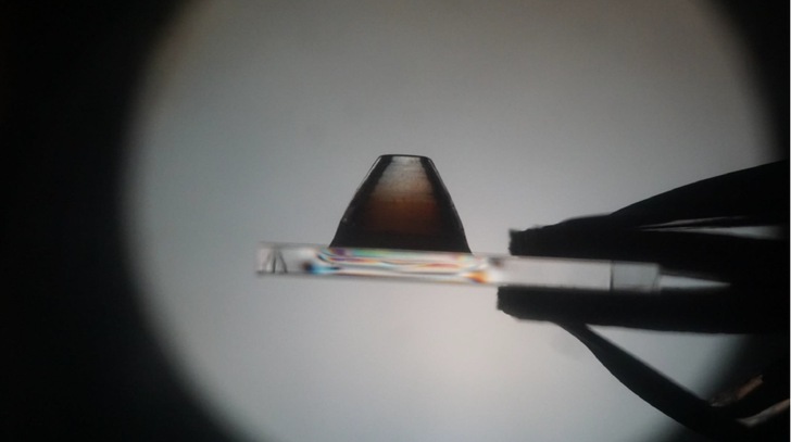 An eine Scheibe angedruckter gläserner Träger in polarisiertem Licht.