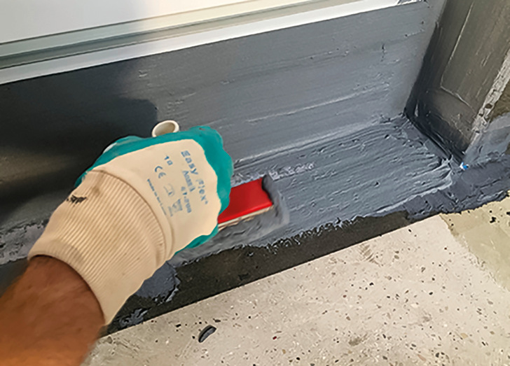 Mit Remmers MB 2K in zwei Arbeitsgängen das Dichtband sowie die Innen- und Außen­ecken vollflächig überarbeiten. Die Gesamttrockenschichtdicke darf 2 mm nicht unterschreiten.