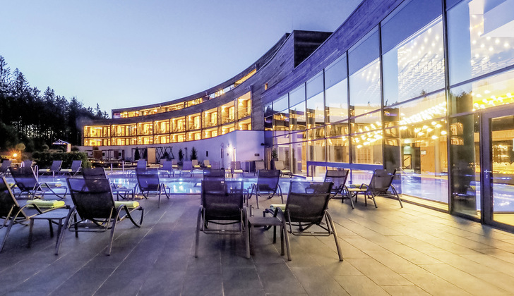 Ein Blick auf die gläserne Fassade des Hotels Rischlhof, die mit ihren Neutralux Gläser von Isolar für ein gutes Innenraum­klima sorgt.