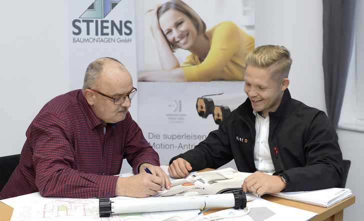 Handwerksmeister Joachim Seise von Stiens Baumontagen (l.) und elero Gebietsleiter Marcel Fellhölter planen die Umrüstung lauter Motoren in einer Mietwohnung. Die Lösung ist RolMotion – zur Freude der Bewohnerschaft.