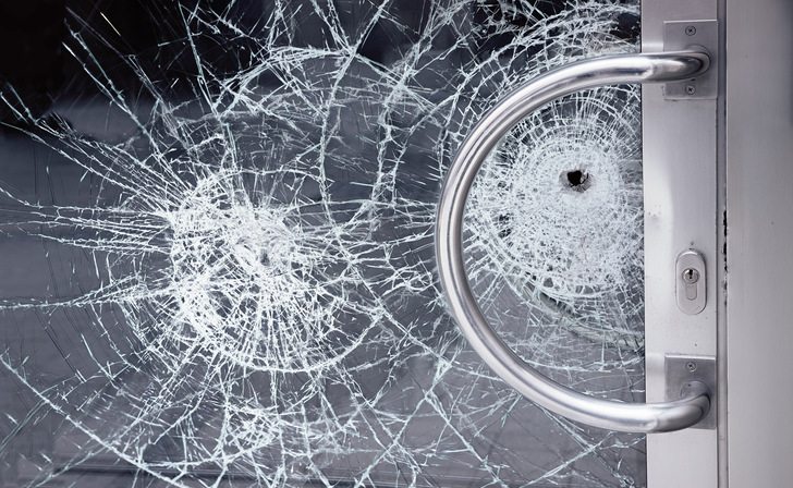 gesplitterte Sicherheits-Glastüre, versuchter Einbruch in ein Büro, mit Durchschuss