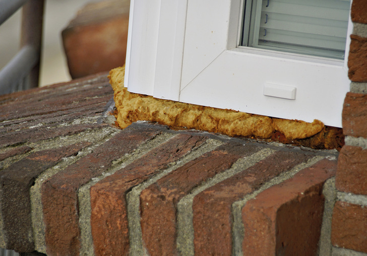 Ausbildung einer Anschlussfuge, eines über Eck gekoppelten Kunststofffensters, einschließlich des unteren Anschlusses zum Verblendmauerwerk. Hier klar zu sehen ist der bereits stark durch UV-Belastung zerstörte PUR-Schaum.