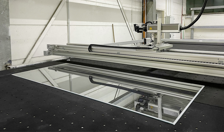 Das Bearbeitungsmodul der Anlage bei Schüt-Duis: Ein ­geführter Laser entfernt am Rand der ­formatierten Glas­scheiben die über Strom  ­ heizende Metall­oxidschicht und ­ermöglicht so eine ­wirtschaftliche serielle Fertigung von Isolierglasheizscheiben.