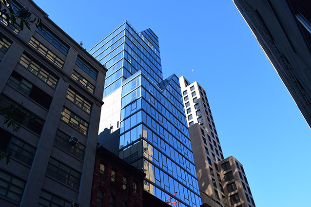 Im New Yorker Stadtteil Manhattan schafft ein großflächig verglaster Turm direkt über einem historischen Gebäude neuen Wohnraum.