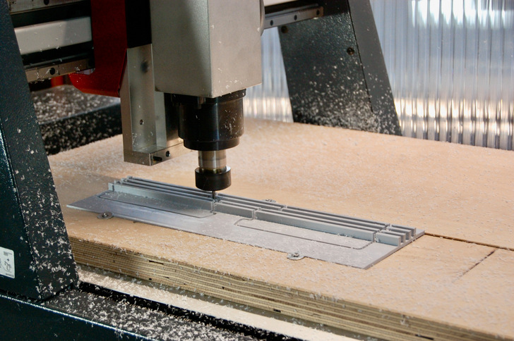 Der Fräskopf frisst sich millimetergenau durch den Kunststoff des Blendrahmenadapters – genau diesen Arbeitsschritt nimmt Alumat auf Grundlage der gelieferten CAD Zeichnung Holzfensterbauern künftig ab.