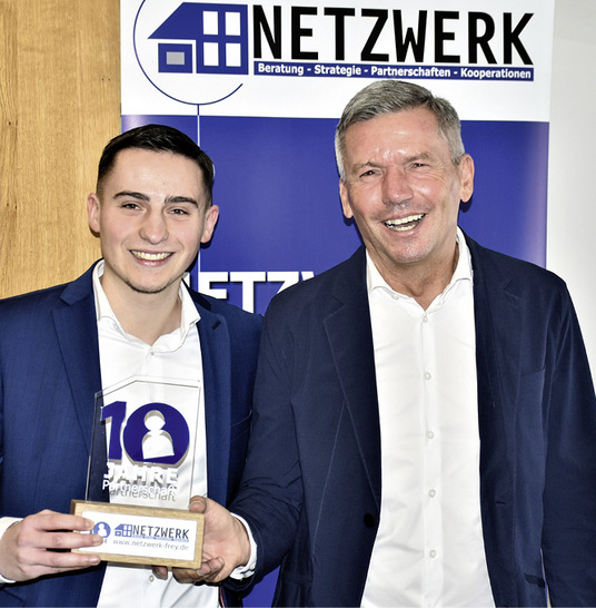 Oliver Frey und sein Sohn Niklas präsentieren am 18.01.2023 den Award, den sie zum Netzwerk-Partnertag den Kunden überreichen werden, die von Anfang an dabei sind. - © Foto: Daniel Mund / GLASWELT
