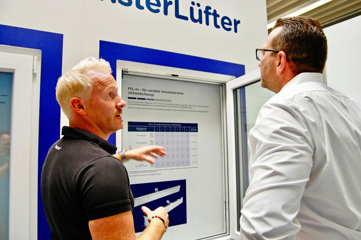 Thomas Verhoeven (l.), Geschäftsführer bei Regel-air, erklärt Denis Fellner im Showroom am niederrheinischen Firmensitz die unterschiedlichen Funktionsweisen der verschiedenen Fensterfalzlüfter.