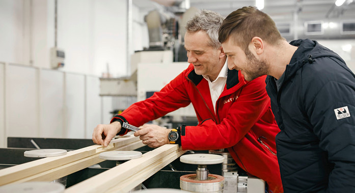 CNC-Maschinist von Telser Türen mit Key Account Veico Strim bei der Begutachtung der Bearbeitungsqualität der Schließblechfräsung