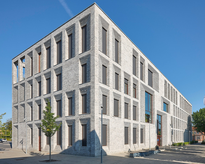 Die Fassade des Rathauses macht durch ihre reliefartige, stufenförmige Struktur auf sich aufmerksam und betont die leicht zurückversetzten Fenster und Türen.