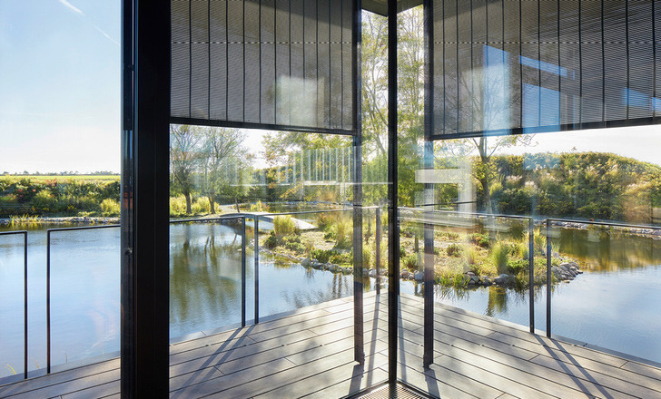 Im Loungebereich erzeugt der geschlossene Metallbehang s_enro gedämpftes, blendfreies Tageslicht und schafft eine ruhige Arbeitsumgebung.