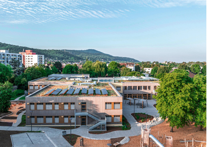 Der Gebäudekomplex vereint Holzmodulbauweise, Passivhausstandard sowie automatisierten Sonnenschutz zu einem integralen Energiekonzept und wurde mit dem German Design Award ausgezeichnet.