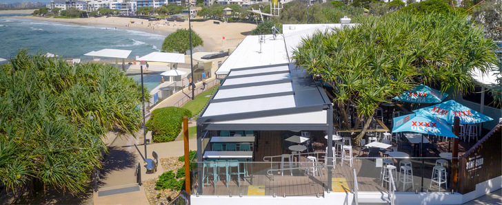 Mehrere pergola stretch-­Anlagen schaffen auf der ­Terrasse des Kings Beach Surf Clubs einen großzügigen, wettergeschützten Außen­bereich mit direktem Blick auf die australische Küste.