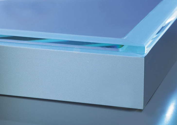 Die Herausforderung bei der Verklebung von Trennwänden liegt im Ausgleich der thermischen Spannungen zwischen Glas und Metall über eine Höhe von bis zu 3 Metern. Mit einer Klebschichtdicke von 2 mm wird dieser Ausgleich erreicht — bei gleichzeitig höchster Festigkeit und absoluter Transparenz.