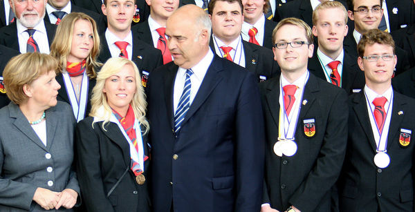 Umringt von Edelmetall: Bundeskanzlerin Angela Merkel und ZDH-Präsident Otto Kentzler (Mitte) rekapitulieren den WM-Erfolg des deutschen Teams. Markus Rauscher (2. von re. vorne) und Lukas Marwitz (re. vorne) haben dazu beigetragen.