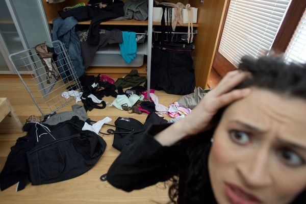 Ein durchwühlter Wäscheschrank und Kleider verteilt auf dem ganzen Boden — eine typische Szene nach einem Einbruch.