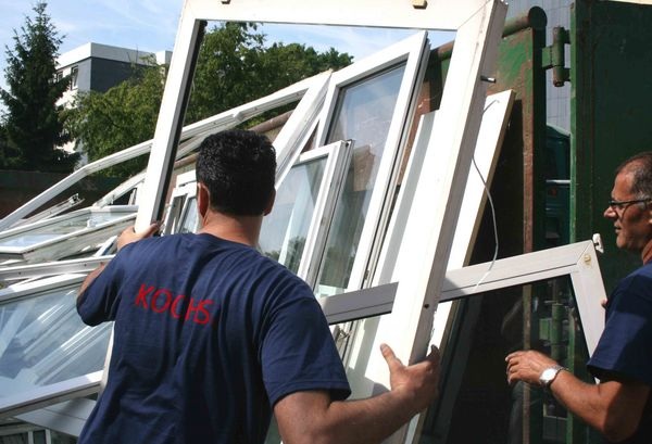 Die ausgebauten PVC-Fenster werden zur Wiederverwertung transportiert.