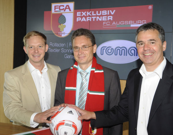 Roma ist ab sofort Exklusivpartner des FC Augsburg. Gemeinsam am Ball: Rouven Kasper vom FCA-Vermarkter 'Sportfive', Roma-Geschäftsführer Roland Uffinger und FCA-Geschäftsführer Andreas Rettig besiegeln die Kooperation zwischen dem Fußballclub und dem Rollladen- und Sonnenschutzspezialist.