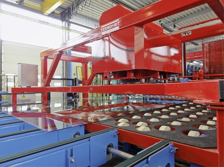 Platzbedarf ­minimiertDie Traveren-Drehvorrichtung ­TraCon von ­Hegla spart Platz, da sie beim Zuschnitt den 90-Grad-Richtungswechsel der Transportstrecke ­zwischen dem X-und dem Y-Brechen über­flüssig macht.