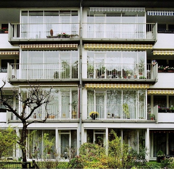 Ansicht auf einen Geschosswohnungsbau aus der ­Siedlung Schillerpark in Berlin mit hohem ­Verglasungsanteil.