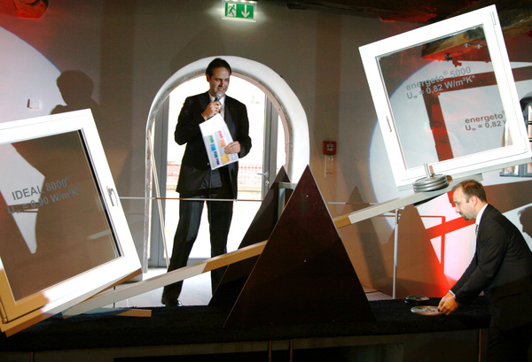 Patrick Seitz erläutert die Waage: Auf der einen Seite das energeto 5000 mit VIG und auf der anderen Seite das energeto 8000 mit konventionellem 3-fach ISO. Andreas Heilig legt als Ausgleich die Gewichte auf.