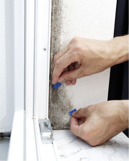 Hier entnimmt ein Sachverständiger eine Schimmelprobe im Laibungsbereich eines Fensters.