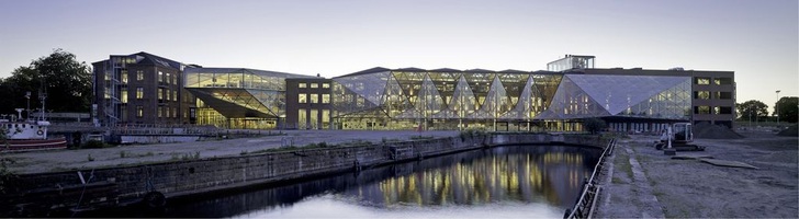 Auch Nachts ein Blickfang: Die leuchtende Fassade den neuen Kulturgebäude (13000 m² Fläche) steht im Kontrast zu den alten Werftgebäuden.