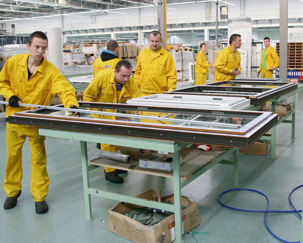 Fensterfertigung in der neuen Produktionshalle: Auffällig viele Mitarbeiter kümmern sich um eine reibungslose Produktion.