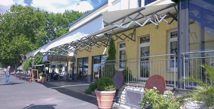 



Durchgehende Tücher sind bei den Gastronomen beliebt, da keine Unterbrechungen entstehen. Mit dem ausfahrenden Leitrohr wird der Tuchdurchhang zudem reduziert und die Regensicherheit der Markise erhöht.
