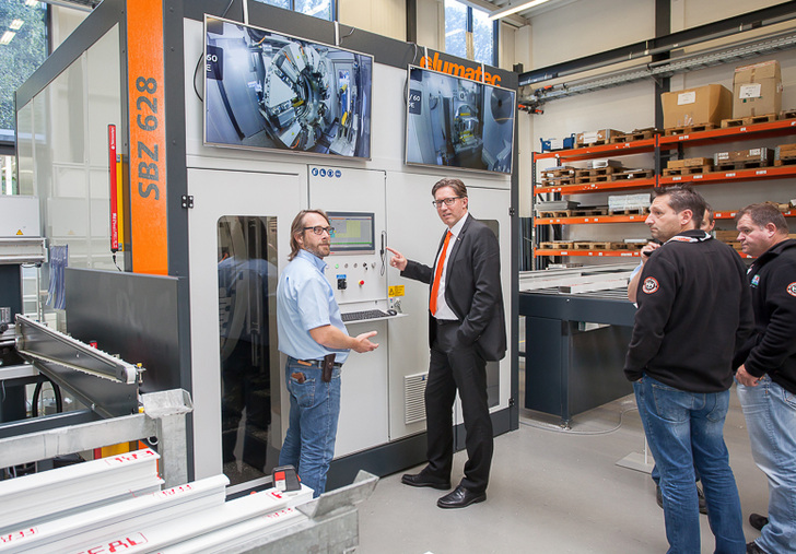 Ralf Haspel (Mitte, mit orangefarbener Krawatte) und ein Mitarbeiter demonstrieren den Besuchern die neue SBZ 628