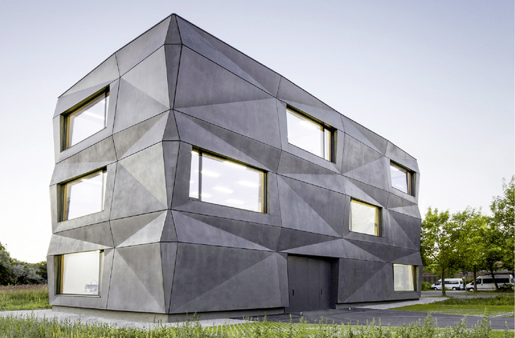 



Der dreigeschossige Baukörper schafft auf einer Bruttogeschossfläche 1135 m
2
 an Büro- und Produktionsräumen. Im ersten und zweiten Geschoss sind eine Druckerei und Stickerei untergebracht, im obersten Geschoss ein Showroom und zwei Büros.
