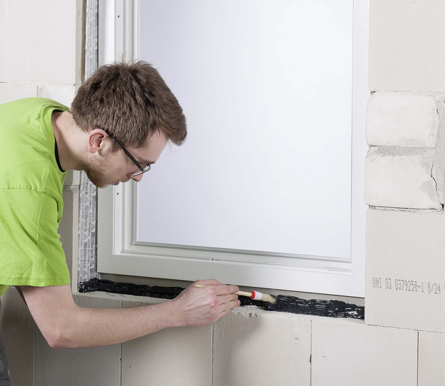 Nach dem Auftragen hat der Verarbeiter 20 min Zeit, die Abdichtungs­beschichtung mit Pinsel oder Spachtel zu verteilen. Selbst Befestigungsanker von Fensterrahmen lassen sich überstreichen oder -sprühen.