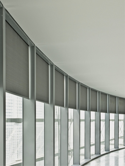 <p>
</p>

<p>
In die Fassadenkonstruktion integrierte Rollos bieten die Möglichkeit, Büros individuell zu verschatten. Anthrazitfarbene Screen-Gewebe mit 10 % Transparenz ermöglichen eine blendfreie Durchsicht nach außen.
</p> - © Fotos: Warema

