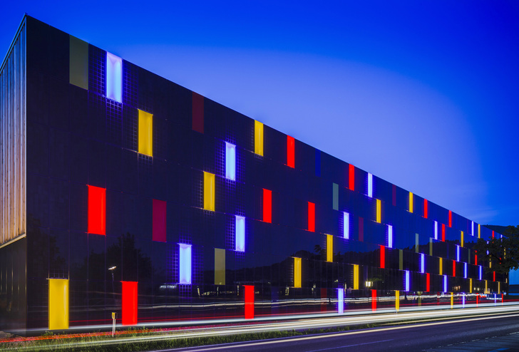 Die in den Firmenfarben leuchtende Fassade der Firma Omicron ist bei Nacht wie bei Tag ein besonderer Blickfang. - © Sunovation
