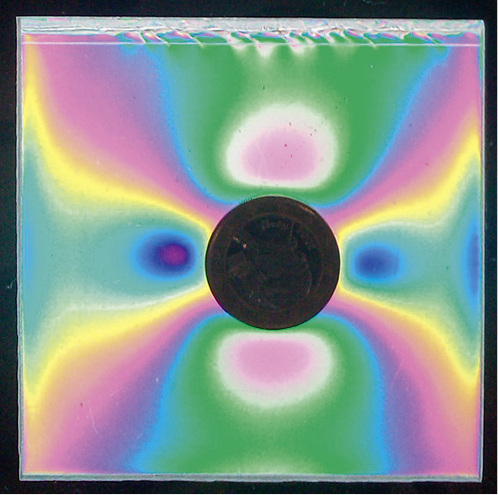 
01: Anisotropien in einem Floatglas mit einer aufliegenden heißen Münze unter einem Polariskop betrachtet.



