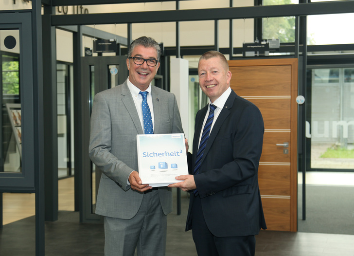 Helmut Meeth (l.), Geschäftsleitung Helmut Meeth GmbH & Co. KG, und Wieland Frank, Geschäftsführender Gesellschafter von Siegenia, bei der Übergabe des neuen Systemsicherheitshandbuchs für RC3.