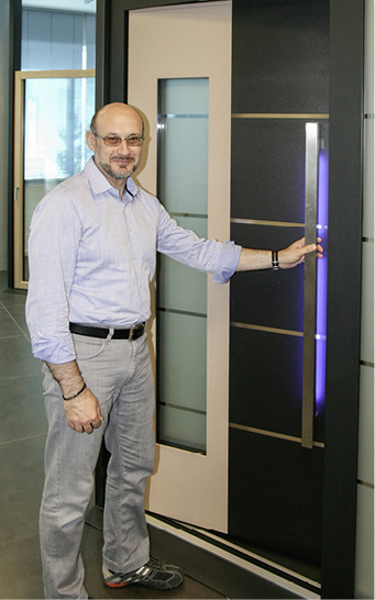 



Alessandro Sbarretti vor einer Tür, die u. a. mit Fuhr-Beschlägen ausgestattet ist.
