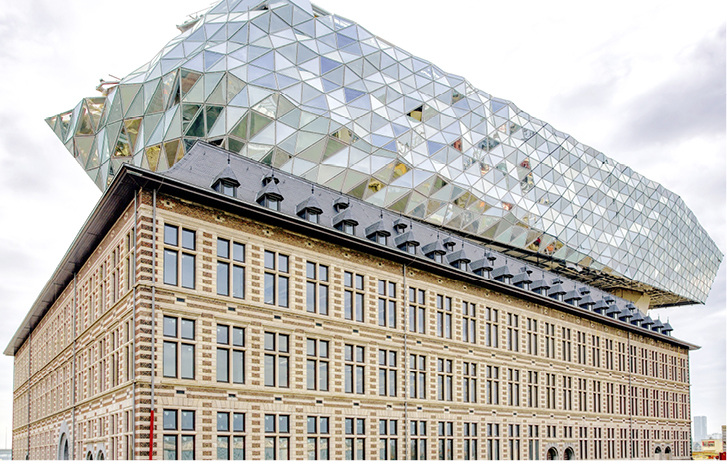 



Um den Ruf von Antwerpen als Welthauptstadt des Diamantenhandels hervorzuheben, besteht die Fassade aus Glasprismen, die je nach Wetter in unterschiedlichen Farbtönen schimmern. Der Sonnenschutz liegt innen.
